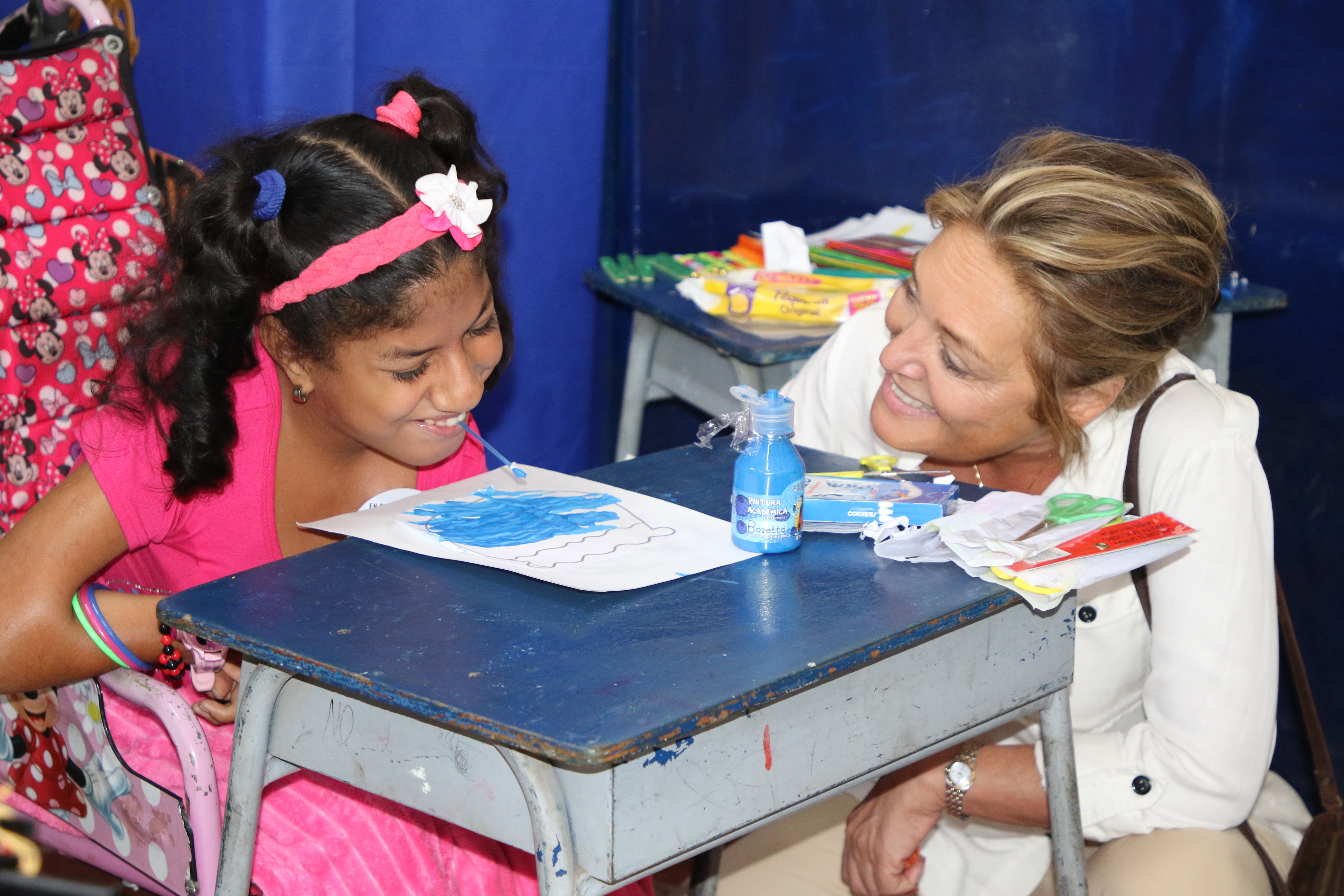 Yasmine Sherif sits with young girl in Colombia