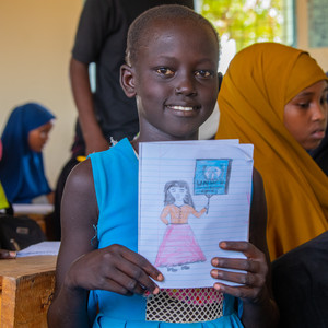 Girl in class holding a drawing