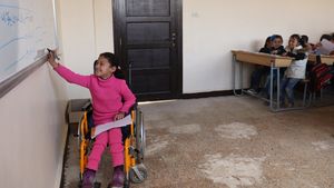 Hanaa, 8, who was paralysed by an exploding bomb and lost the use of her legs, solves a problem on a whiteboard in a classroom at a school in east Aleppo city, Syrian Arab Republic, February 2018. Hanaa's dream is to become a physiotherapist to help children like her. ©UNICEF/Al-Issa