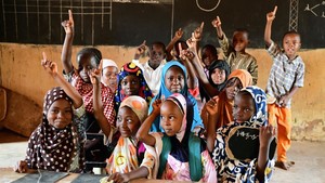 Students raise their hands in the classroom. Photo credit: UNICEF / Dejongh