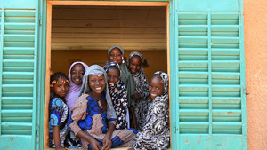 Young adolescents facing camera on a classroom window
