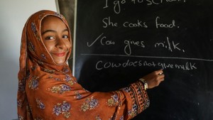 Girl writing on blackboard