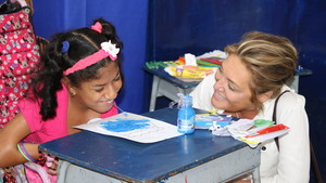 Yasmine Sherif sits with young girl in Colombia