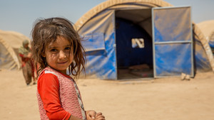 Girl stands in displacement camp.