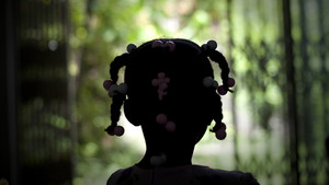 Young girl from Haiti with her back to the camera.
