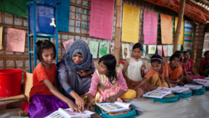 Teacher in Bangladesh works with a student on reading.