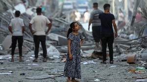 Palestinian child in the street amidst the wreckage of homes destroyed by airstrikes in the Gaza Strip