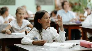 Darya raises her hand in class in Moldova.