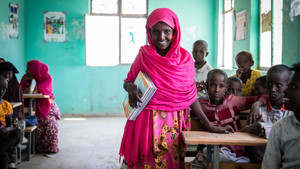 Girl posing for a picture at a classroom