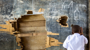 Children writing on an impacted blackboard