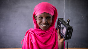 Girl holding a radio in a classroom