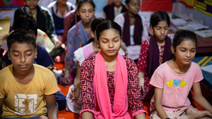 Schoolgirls meditating in a classroom in Bangladesh