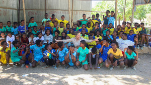 Group photo of Yasmine Sherif and children smiling at a school playground in Ethiopia