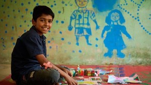 Boy sitting on the floor with art supplies