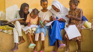 Group of girls reading, writing and looking at their notebooks