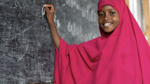 Young girl in Somalia writes on the board in her class.