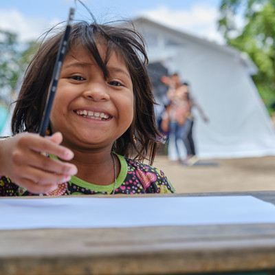 Girl smiling holding a pencil