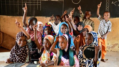 Students raise their hands in the classroom. Photo credit: UNICEF / Dejongh