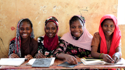 Girls inside a classroom smiling
