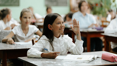 Darya raises her hand in class in Moldova.