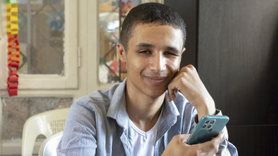 A teenage boy, Ali, with vision impairment smiles in Syria.