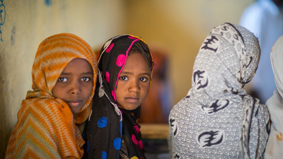 Girls at a classroom looking straight to the camera