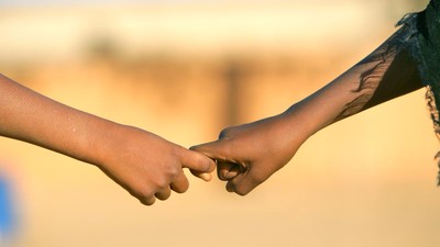 Photo of 2 children holding hands