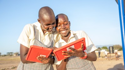 2 schoolgirls holding a tablet