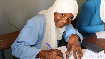 Girl attending class writing in her notebook