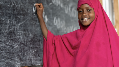 Young girl in Somalia writes on the board in her class.