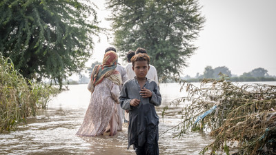 Boy walking through the flood in Pakistan