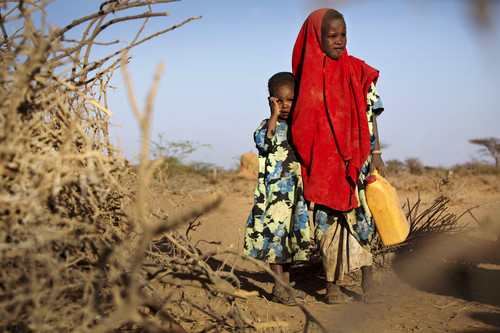 two children walking on a drought zone