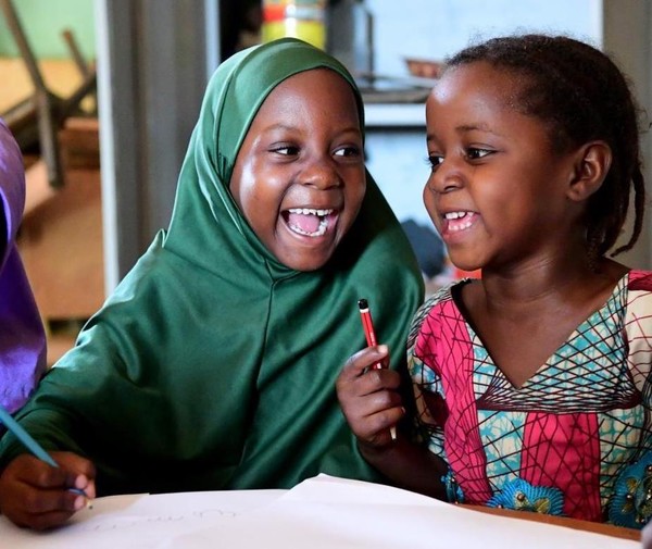 Young girls in Niger laugh in the classroom.