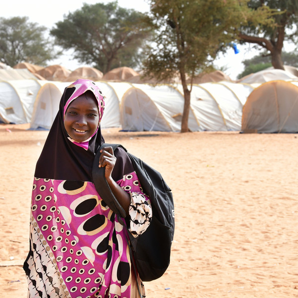 Girl smiling carrying a schoolbag