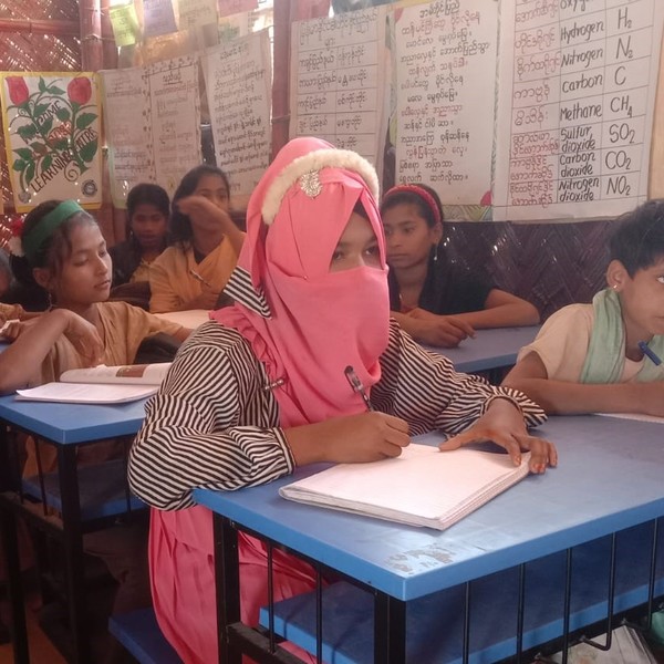 Girl attending class writing in her notebook