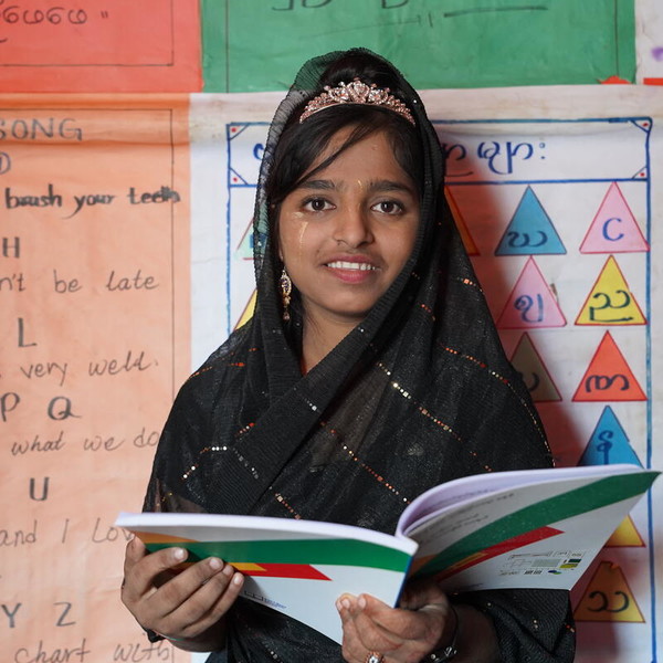 Girl holding a book smiling to the camera