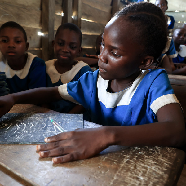 Girl during class writing on a chalk board