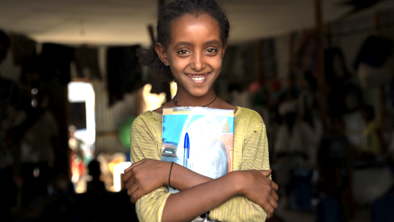 Ethiopian girl smiling and holding books