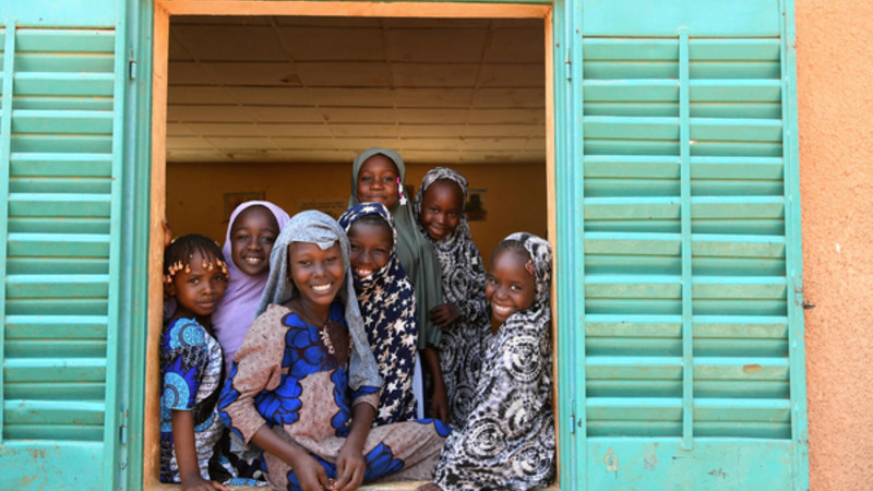Young adolescents facing camera on a classroom window