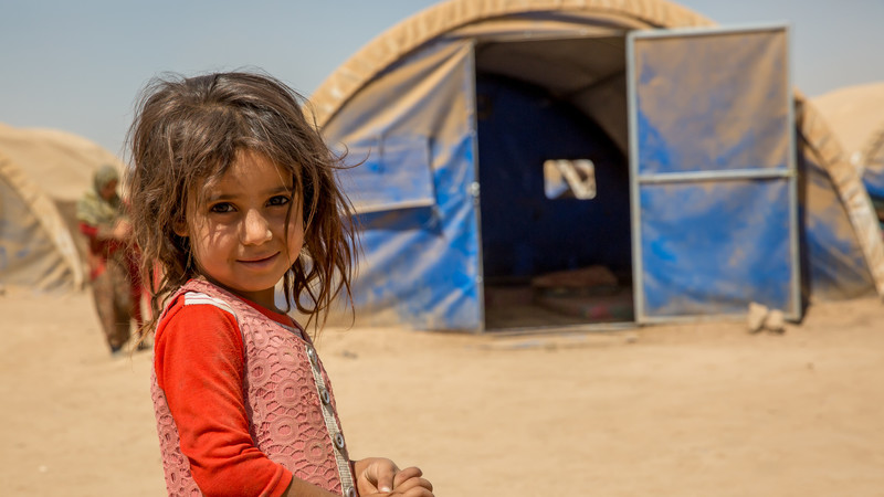 Girl stands in displacement camp.