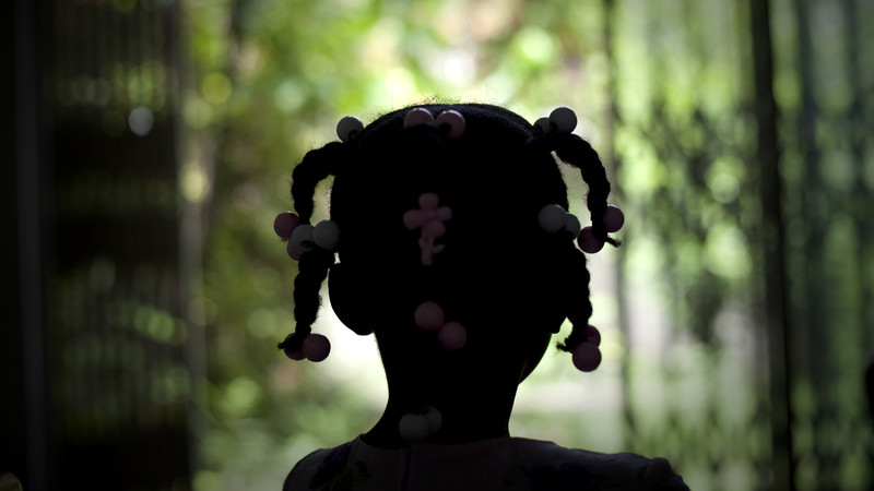 Young girl from Haiti with her back to the camera.