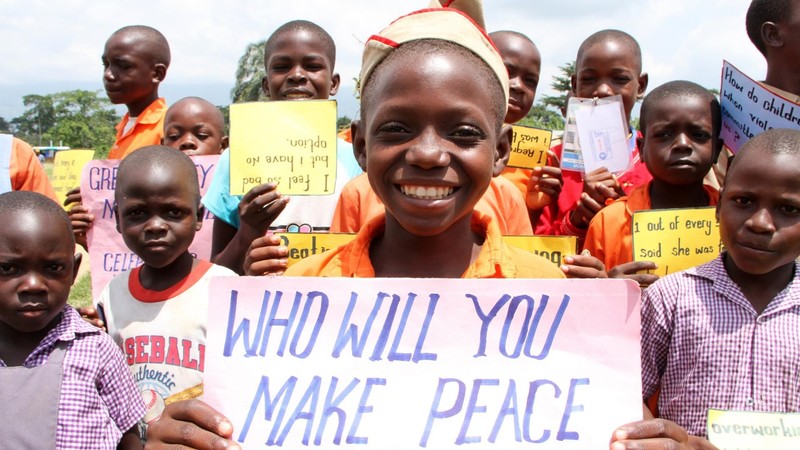 An African girl holding a sign "Who will make peace with"