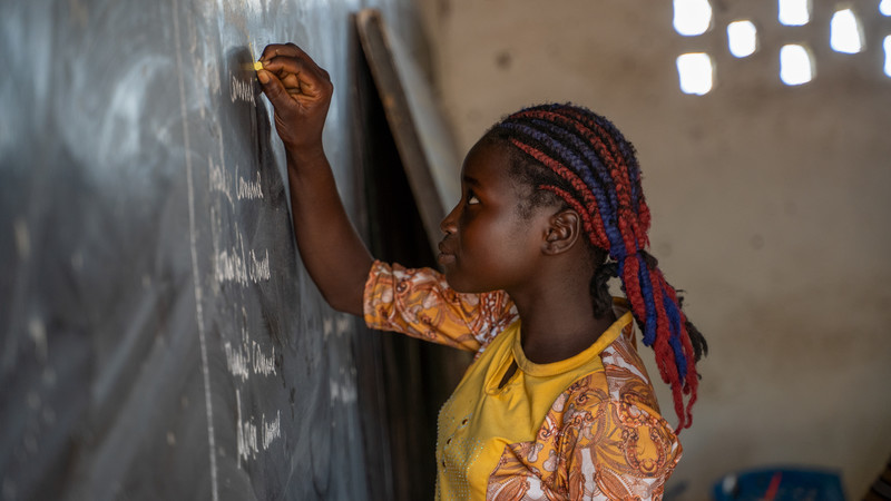 Girl writing on blackboard