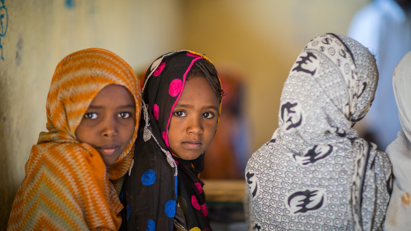 Girls at a classroom looking straight to the camera