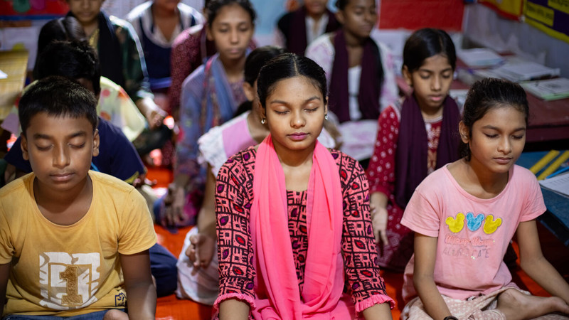 Schoolgirls meditating in a classroom in Bangladesh
