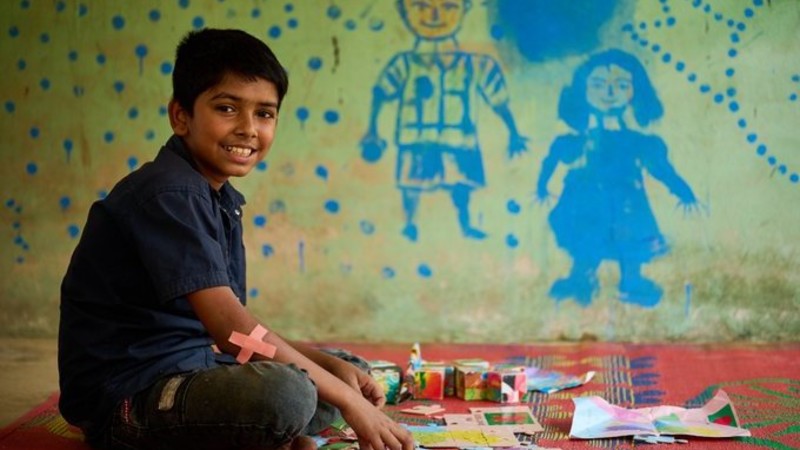 Boy sitting on the floor with art supplies