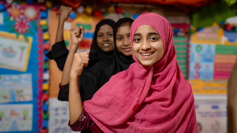 Girls posing for the camera smiling and flexing their arms