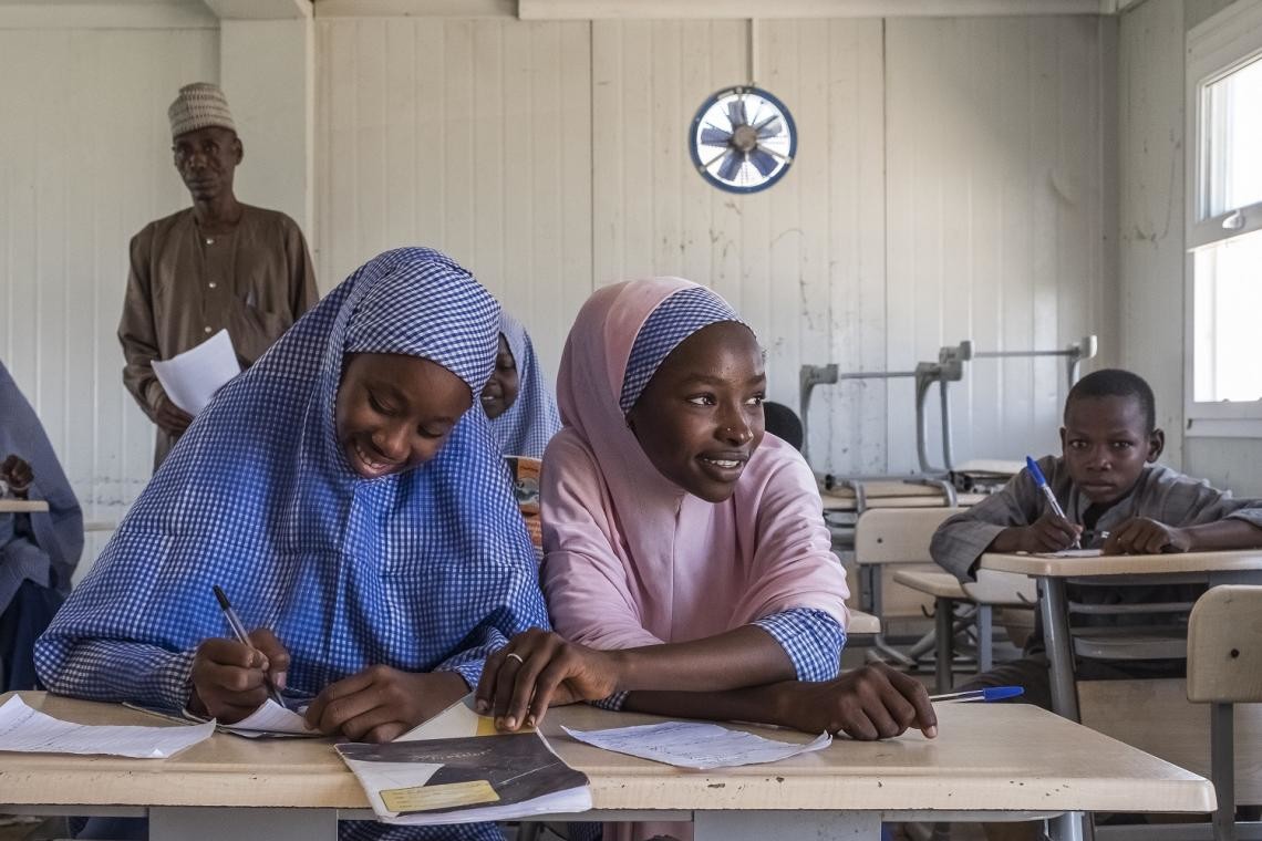 Two adolescent girls attending class