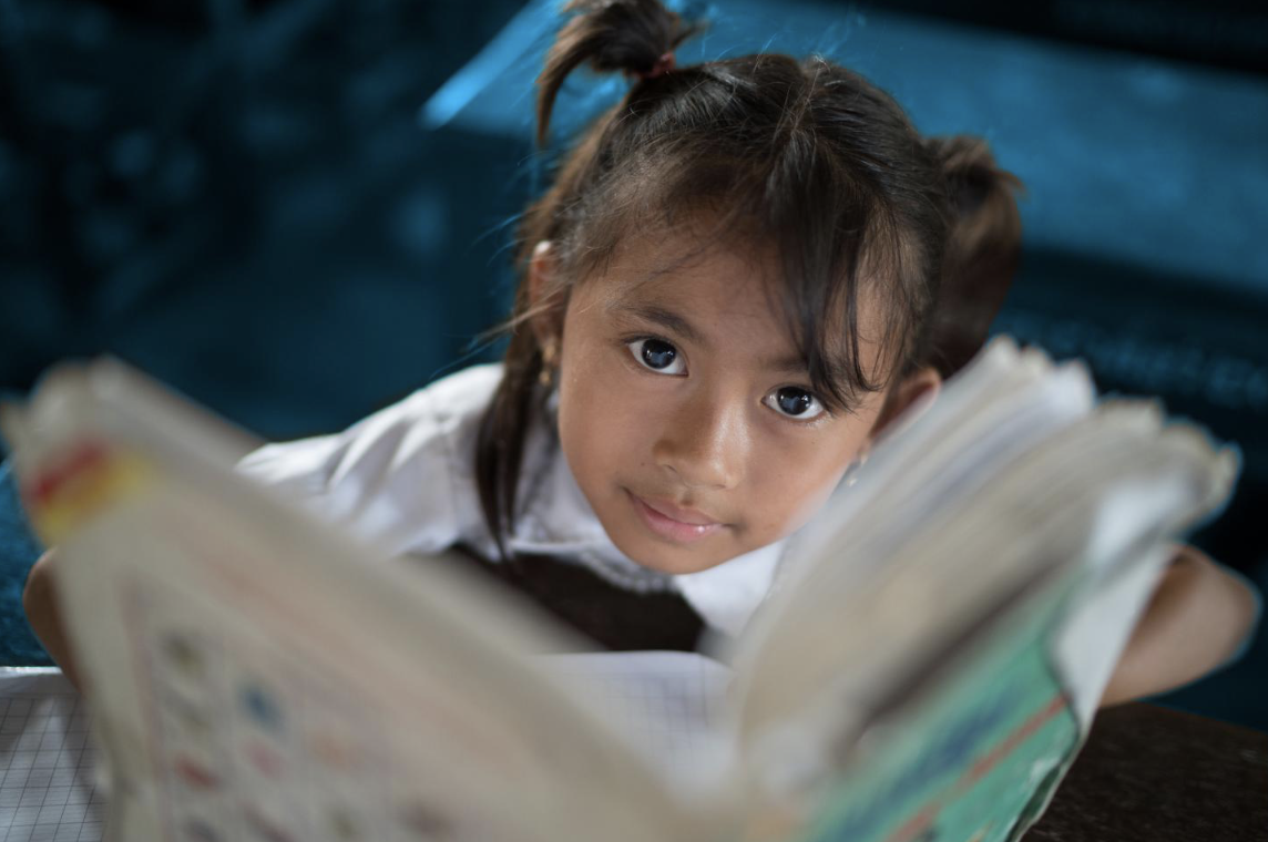Girl attending class holding a book