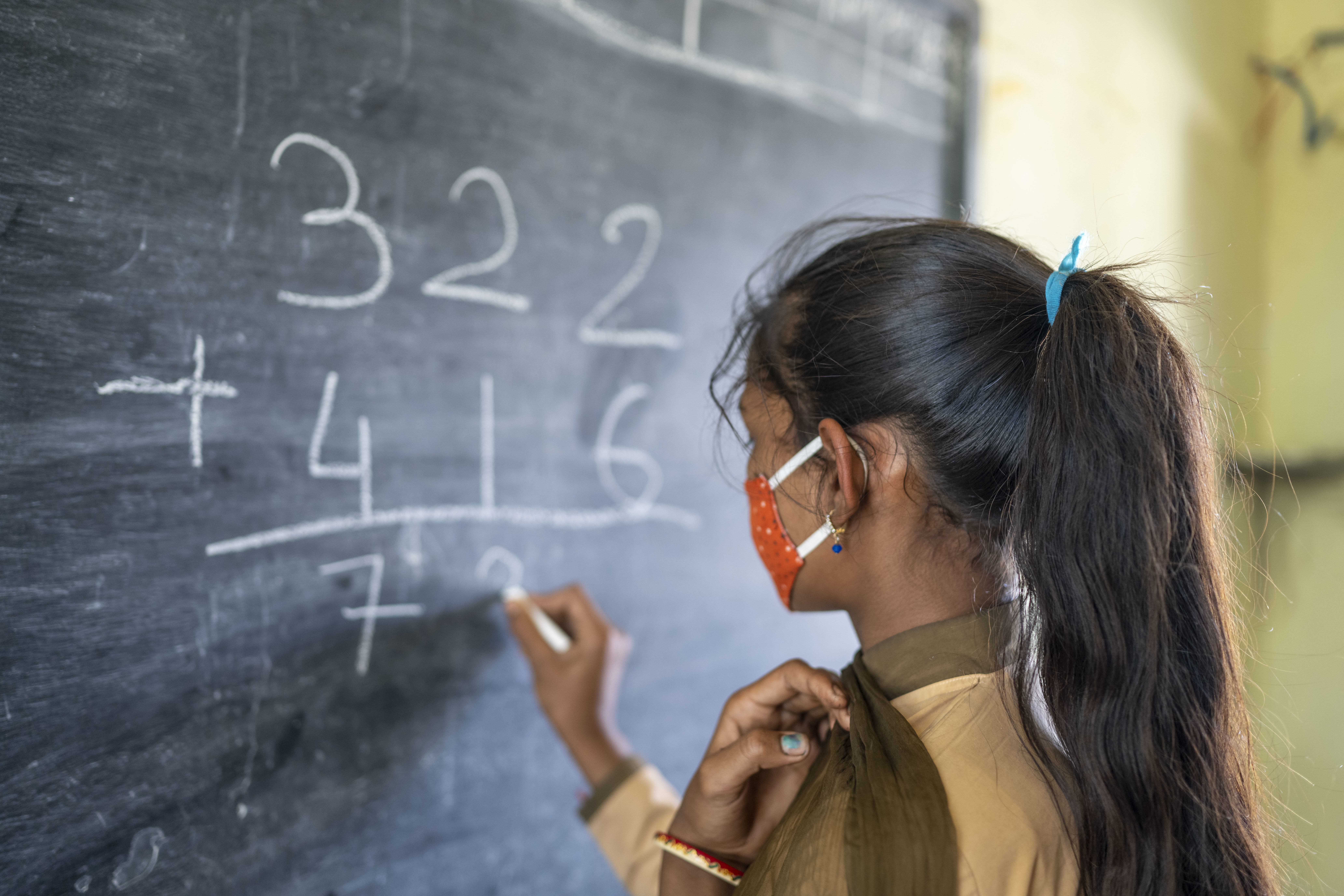 Girl writing on a blackboard